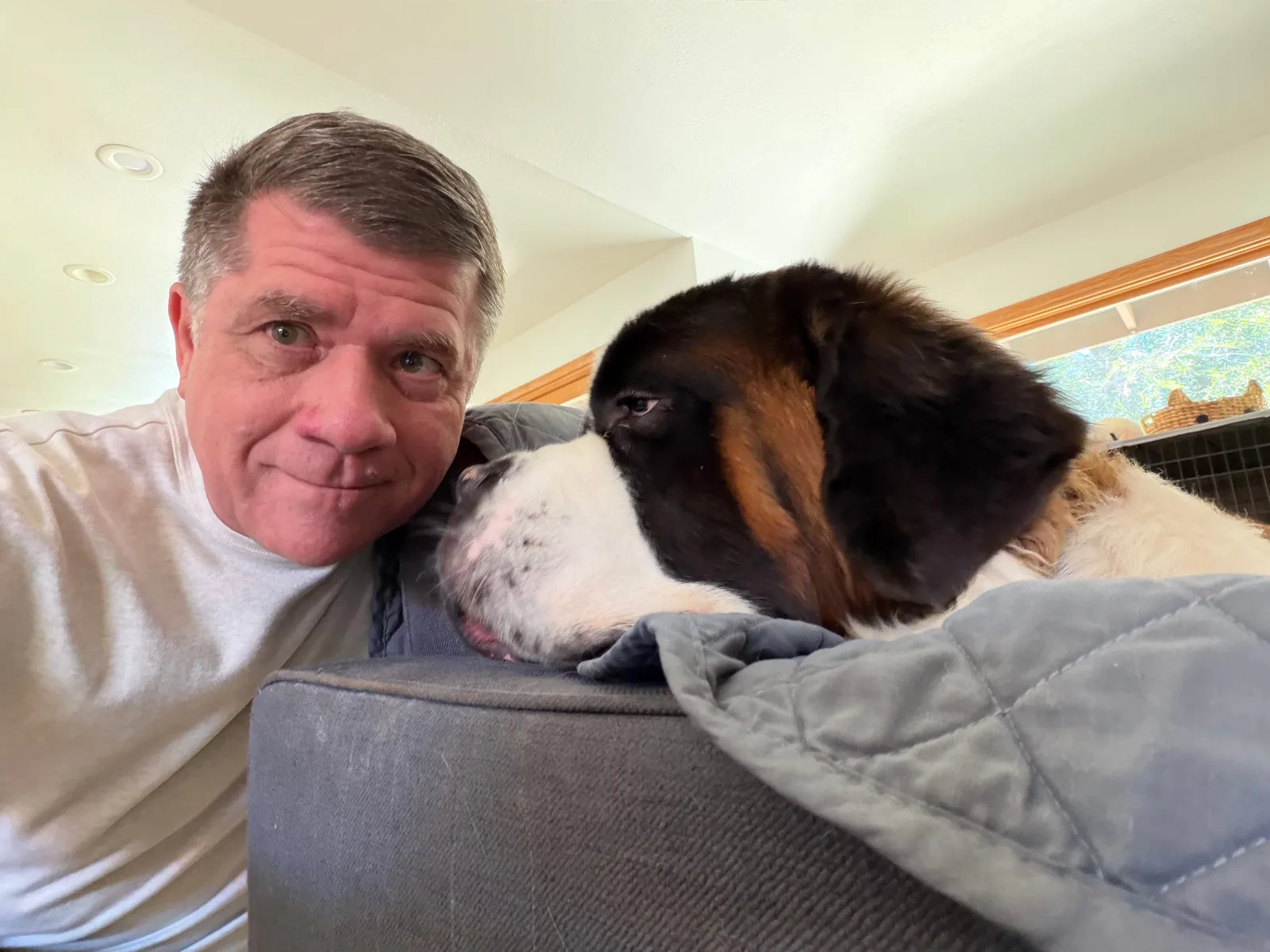 Steve leaning his head against the back of the couch for a selfie, with Magnus resting his head right beside him, the two of them almost nose to nose.